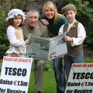 Mark Cagney, Claire Byrne and children posing with newspaper.